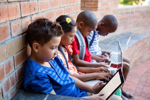 Uczniowie Za Pomocą Tabletu I Laptopa Na Szkolnym Korytarzu