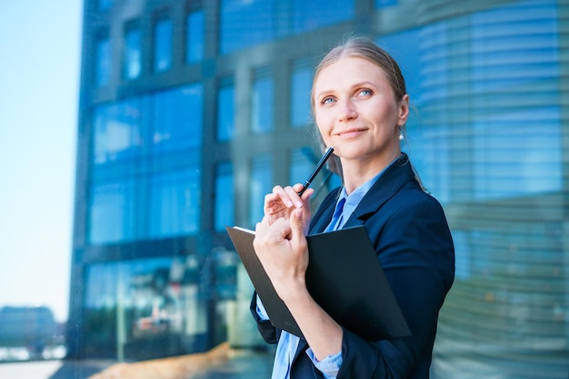 Udane businesswoman robienie notatek podczas chodzenia na zewnątrz Kobieta biznesu