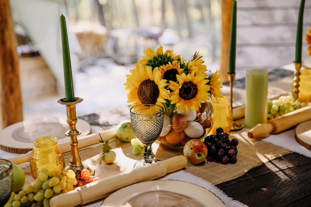 Udekorowany stół na imprezę o tematyce wiejskiej ze słonecznikami i owocami