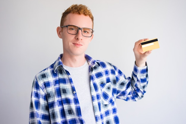Ufny mężczyzna reklamuje kredytową kartę w szkłach