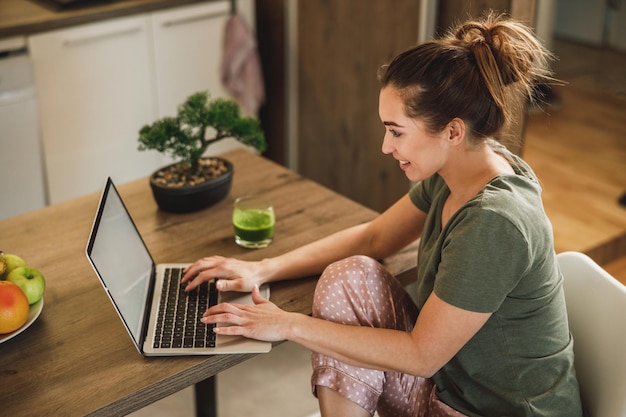 Ujęcie Kobiety Korzystającej Z Laptopa Podczas Picia Koktajlu Rano W Domu.