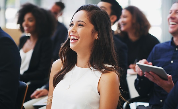 Ujęcie szczęśliwej młodej bizneswoman siedzącej na audytorium konferencji biznesowej