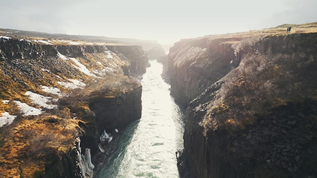 Ujęcie z drona wodospadu Gullfoss na Islandii, majestatyczna kaskada przepływająca pomiędzy wzgórzami kanionu nordyckiego. Islandzki strumień wody spadający z klifów. Zwolnione tempo.