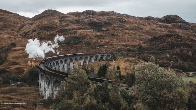 Ujęcie z wysokiego kąta słynnego historycznego pociągu parowego w wiaduktu Glenfinnan w Szkocji