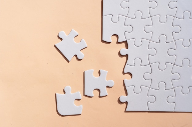 Układanki puzzle nieposortowane elementy na różowym tle