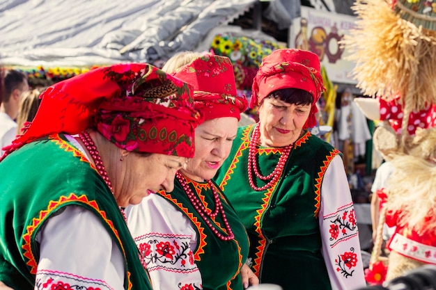 Zdjęcie ukrainki ubrane w tradycyjne ukraińskie stroje z czerwonymi szalami i koralikami