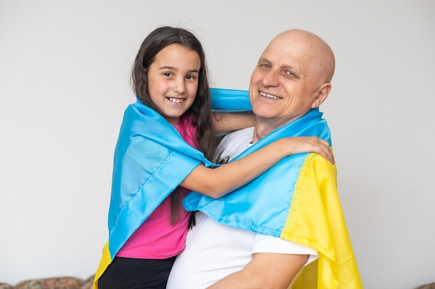 Ukraiński dziadek i wnuczka z laptopem i flagą Ukrainy