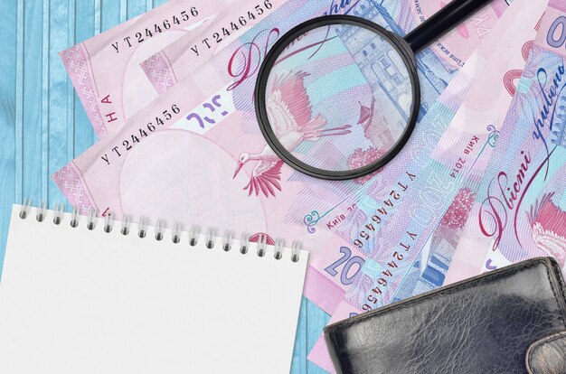 Ukraińskie hrywny rachunki i szkło powiększające z czarną torebką i notatnikiem
