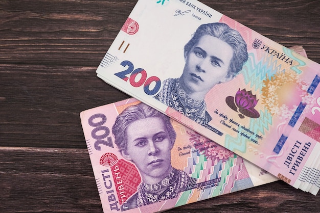 Ukraińskie pieniądze na drewnianym tle. Nowe i stare banknoty 200 hrywien.