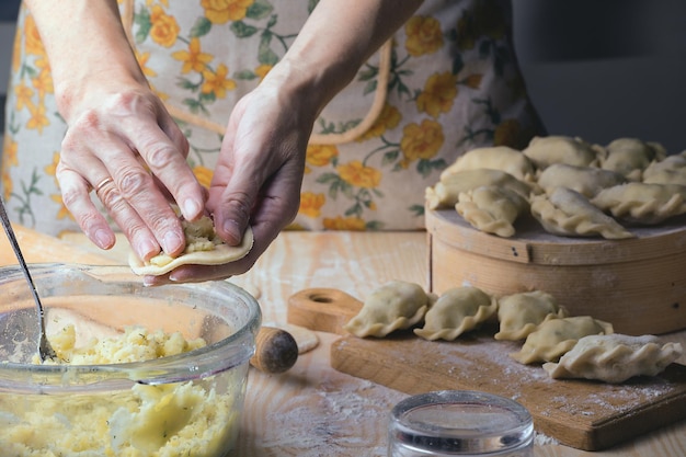 Ukraińskie tradycyjne wyroby piekarnicze - Robienie pierogów kobiecymi rękami. Styl rustykalny. Retro zdjęcie