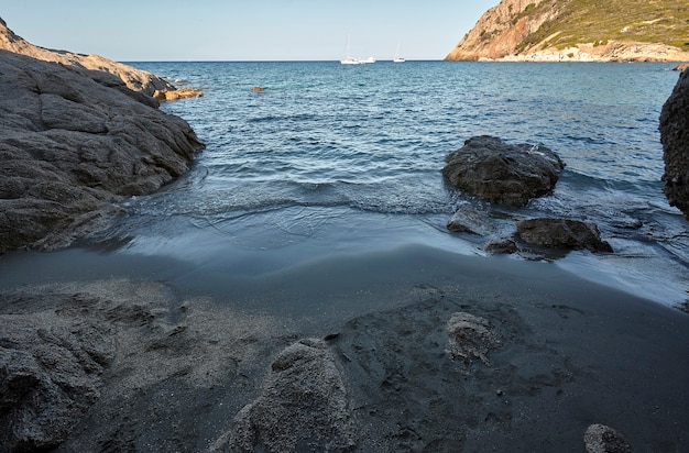 Ukryta plaża wśród skał przy wyjściu z naturalnej jaskini na południu Sardynii