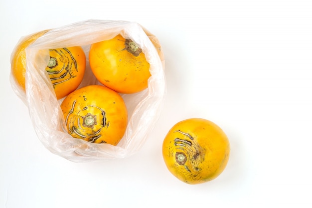 Zdjęcie ulgly organiczne żółte pomidory w plastikowej torbie, zdjęcie pokazuje szkodliwość używania sztucznych toreb do przechowywania żywności