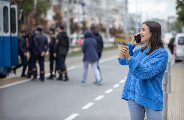 Ulica Portret Młodej Kobiety Rozmawia Przez Telefon W Mieście W Pobliżu Jezdni.