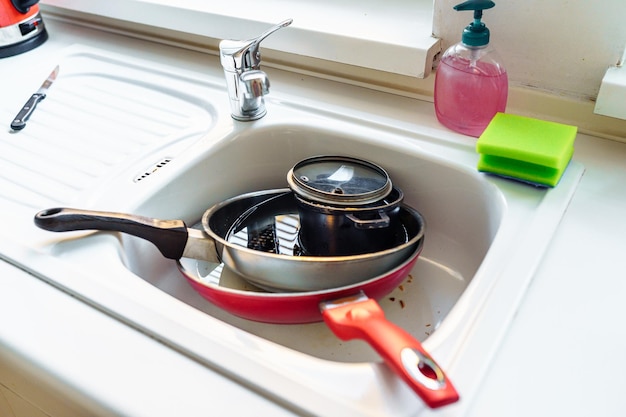 Ułóż brudne, nieumyte naczynia w zlewie kuchennym
