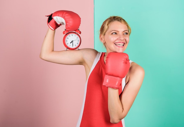 Umiejętności zarządzania czasem poranna energia pełna mocy czas aktywności Ustalenie zegara czas czas na sukces wygraj dzień szczęśliwa kobieta rękawice bokserskie dziewczyna bokser trzymaj budzik