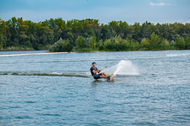 Umiejętny wakeboarder tnący wodę krawędzią deski tworzący rozpryski