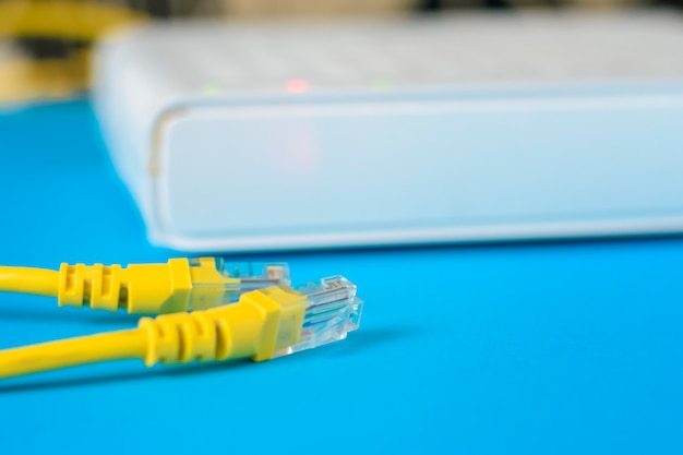 Unplugged ethernet cable i internet router na niebieskim tle