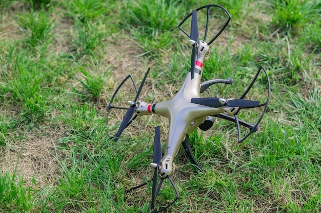 Upadły dron na zielonej trawie po odłączeniu pilota
