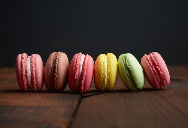 Upieczone kolorowe ciasteczka macarons leżą w rzędzie