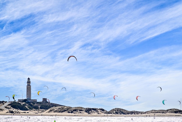 Uprawianie kitesurfingu na plaży Los Caos de Meca obok latarni morskiej Trafalgar Barbate.