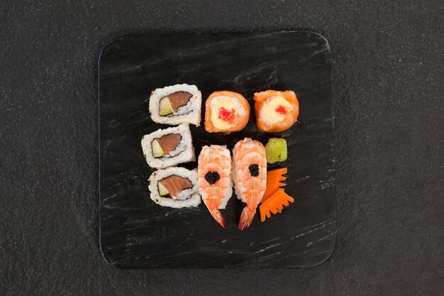 Uramaki i nigiri sushi serwowane w czarnym kamiennym łupku