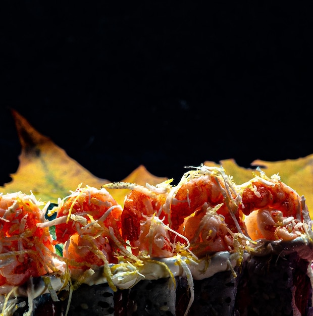 Uramaki philadelphia z łososiem z krewetkami i skórką z sycylijskiej cytryny na talerzu o orientalnej teksturze