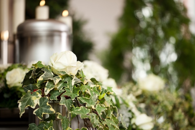 Zdjęcie urna pogrzebowa ze świecami i kwiatami