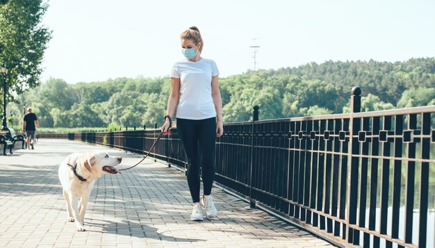 Urocza Dama Z Medyczną Maską Na Twarzy I Blond Włosami Budzi Się Nad Jeziorem Z Golden Retriever