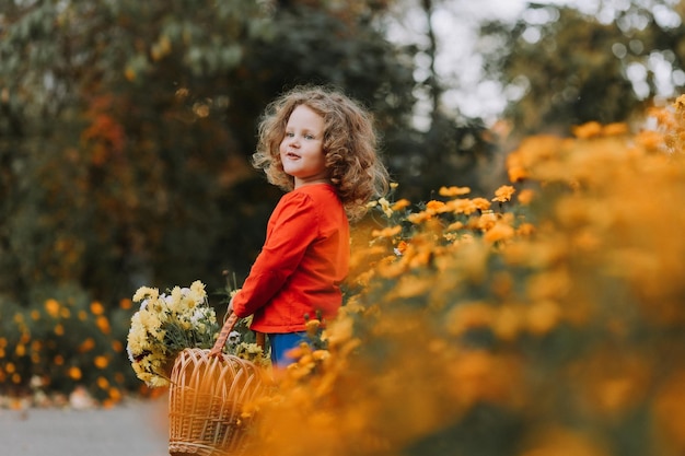 Urocza Kręcona Dziewczynka W Czerwonej Koszuli W Parku Z Koszem Kwiatów W Czasie Jesieni Zdrowie Jesieni