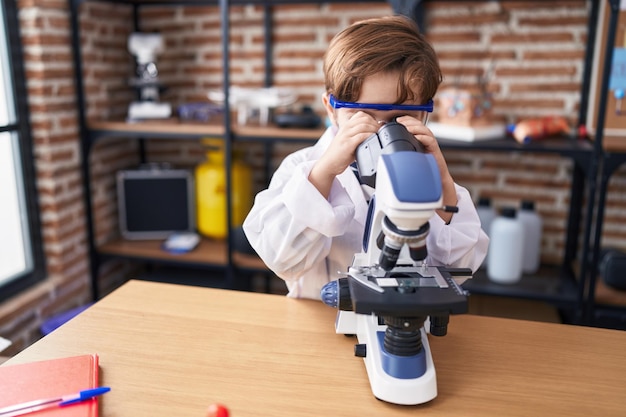 Urocza latynoska studentka używająca mikroskopu w klasie laboratoryjnej
