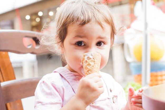 Urocza Mała Dziewczynka Je Lody W Kawiarni Na świeżym Powietrzu