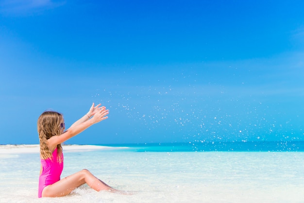 Urocza mała dziewczynka przy płytką wodą na plaży