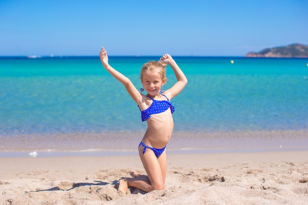 Urocza mała dziewczynka robi kołu na tropikalnej białej piaskowatej plaży