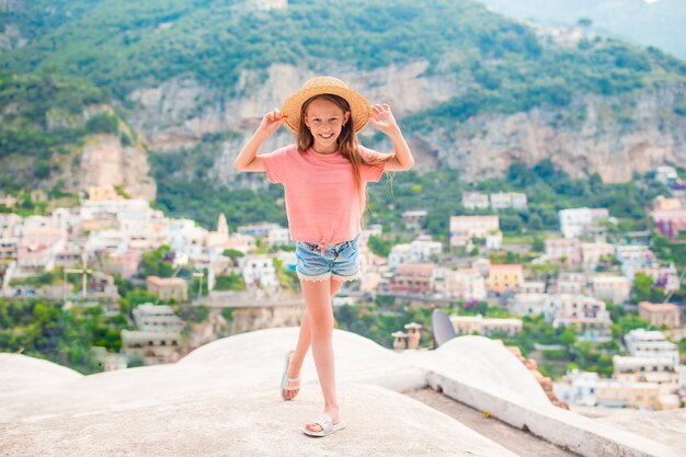 Urocza mała dziewczynka w ciepły i słoneczny letni dzień w miasteczku Positano we Włoszech