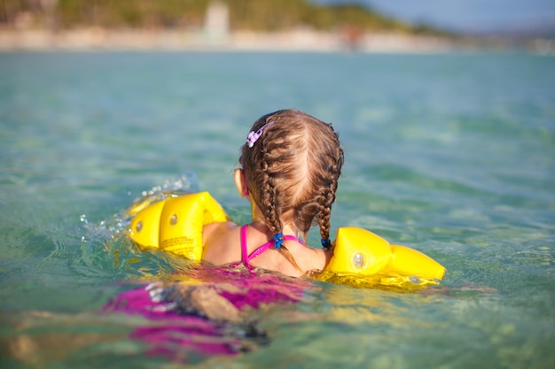 Urocza małej dziewczynki dopłynięcie w morzu na tropikalnej plaży wakacje