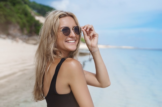 Urocza młoda kobieta korzystających z letnich wakacji w słonecznej, piaszczystej plaży