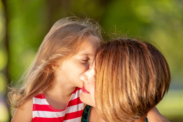 Urocza młoda mama i córka w ciepły słoneczny letni dzień Szczęśliwa rodzina matka i dziecko córeczka bawią się i chodzą po parku i cieszą się piękną przyrodą