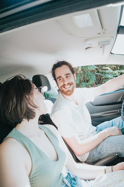 Urocza młoda para podróżuje samochodem. Droga, przedni uśmiechnięty portret. Hipster nowoczesny para oglądając się nawzajem.