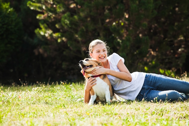 Urocza nastolatka bawi się z psem rasy beagle w parku