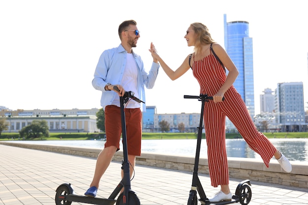 Urocza para bawiąca się jazda skuterem elektrycznym wzdłuż miejskiej promenady.