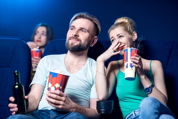 Urocza para oglądająca film siedząca razem z popcornem w kinie