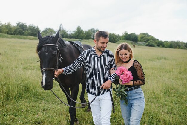 Urocza zakochana para obejmująca się w pobliżu konia