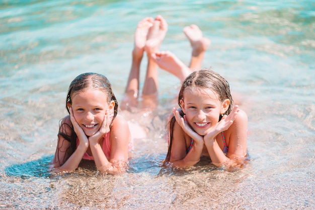 Urocze dziewczynki bawiące się na plaży