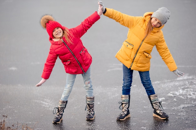 Urocze dziewczynki jeżdżące na łyżwach na lodowisku