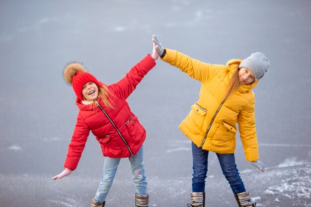 Urocze dziewczynki jeżdżące na łyżwach na lodowisku