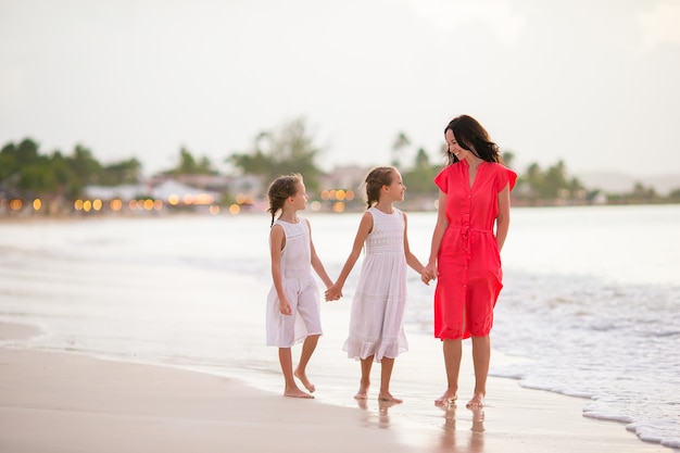 Urocze małe dziewczynki i młode matki na białej plaży
