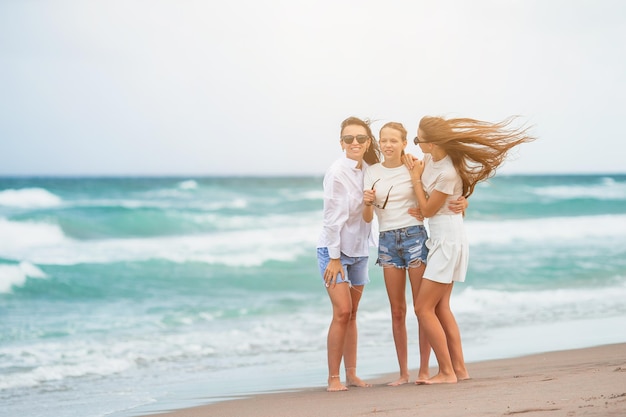 Urocze małe dziewczynki i młode matki na tropikalnej białej plaży