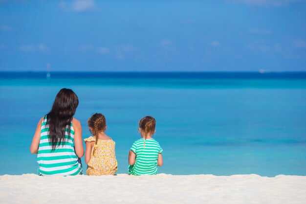 Urocze małe dziewczynki i młode matki na tropikalnej białej plaży