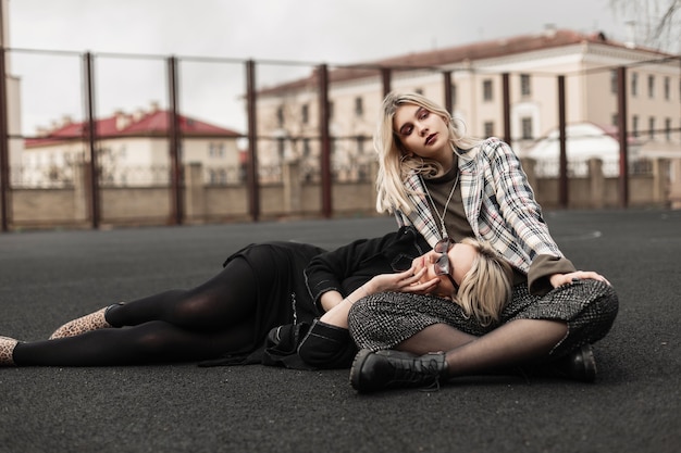 Urocze modne bliźniaczki odpoczywają na placu zabaw
