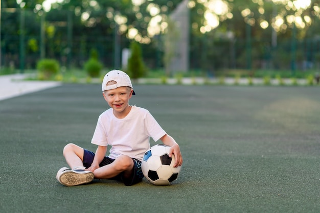Urocze sportowe dziecko na boisku piłkarskim